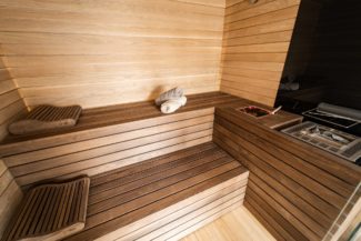 Ce sauna pourvu d'une technique bio est réalisé avec des banquettes foncées et une paroi plus claire.